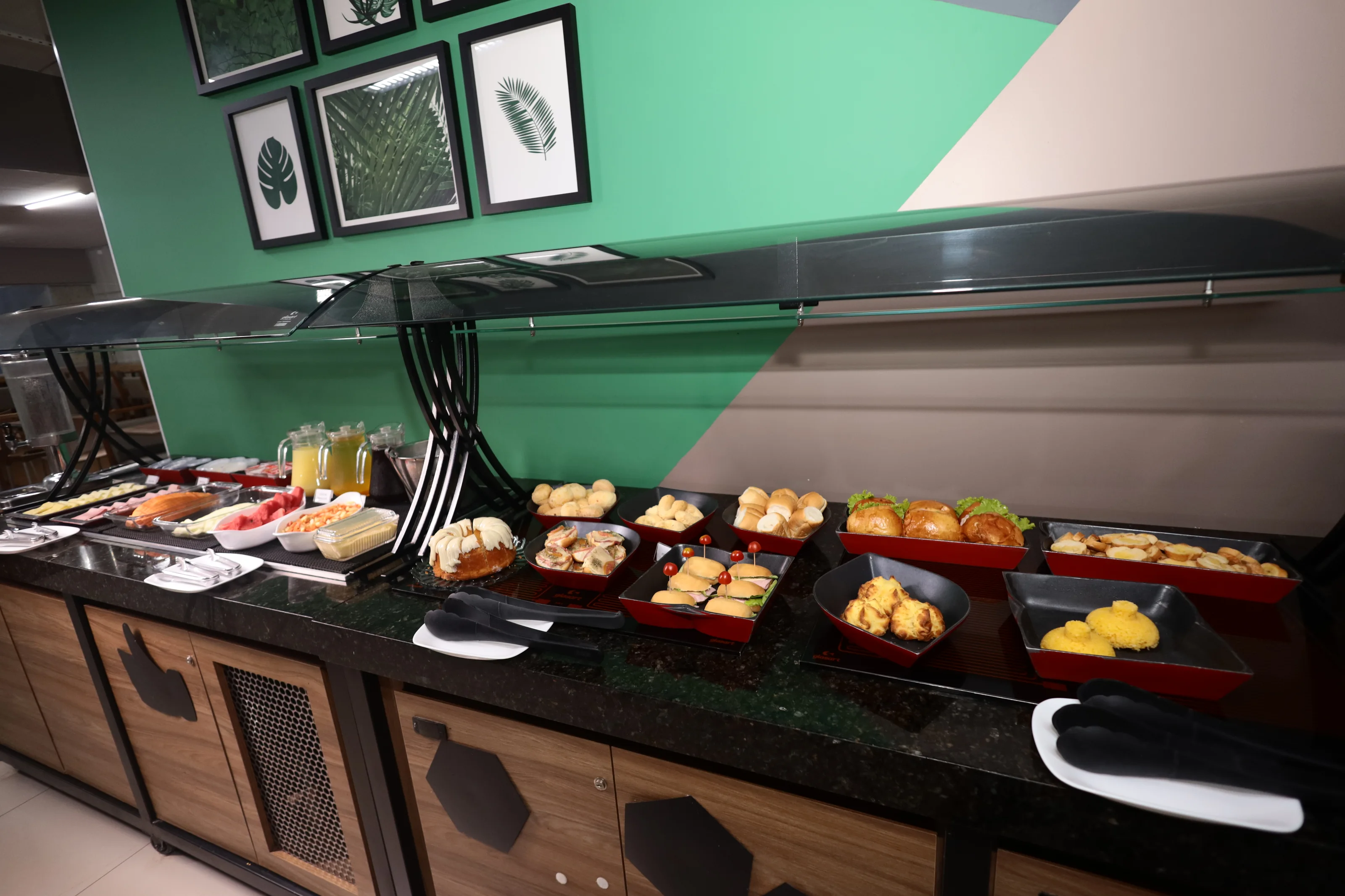 Buffet de café da manhã do House Inn Hotel, com pães, frios, frutas e bebidas